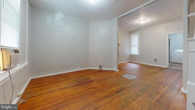 a view of empty room with wooden floor