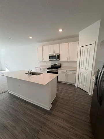 a kitchen with wooden floors and white appliances