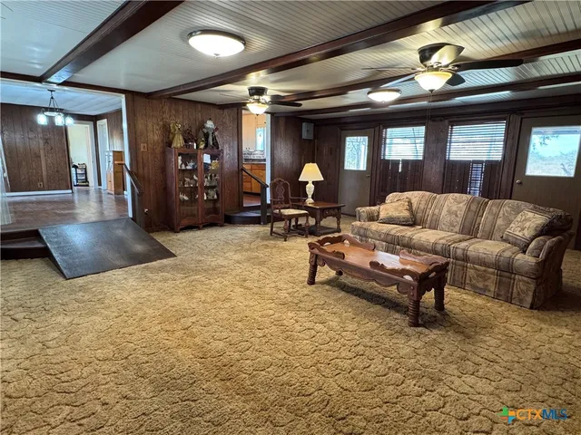 a living room with furniture and a chandelier