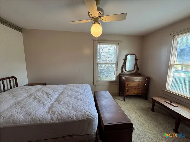 a bedroom with a bed a chandelier and a window