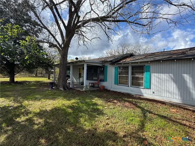 a view of a house with a yard patio and fire pit