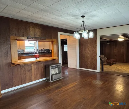 wooden floor in an empty room with a kitchen