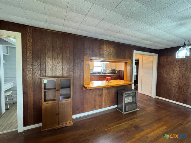 a kitchen with stainless steel appliances wooden floor and a refrigerator