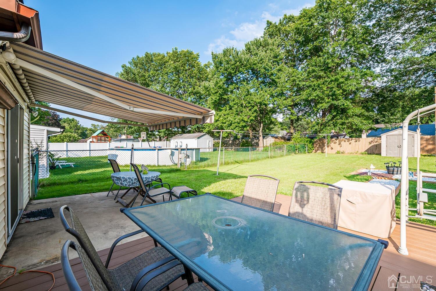 43 Kenmore Road Edison, NJ 08817 - Photo 16 of 19 a view of a patio with table and chairs under an umbrella with a small yard
