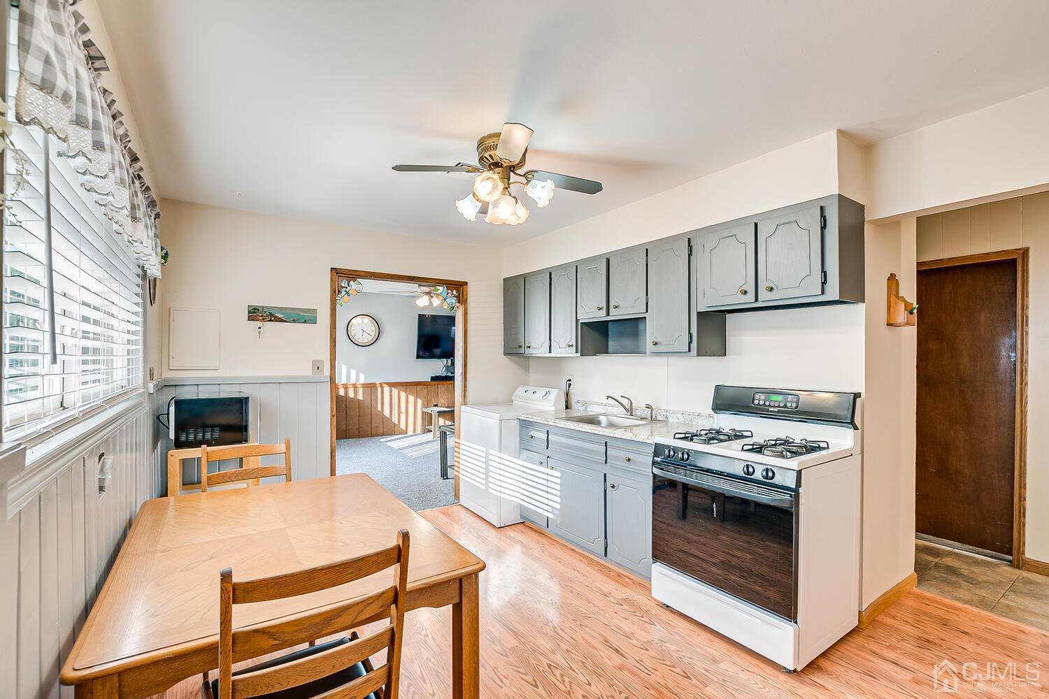 43 Kenmore Road Edison, NJ 08817 - Photo 7 of 19 a kitchen with stainless steel appliances a stove a sink dishwasher a refrigerator with white cabinets and wooden floor