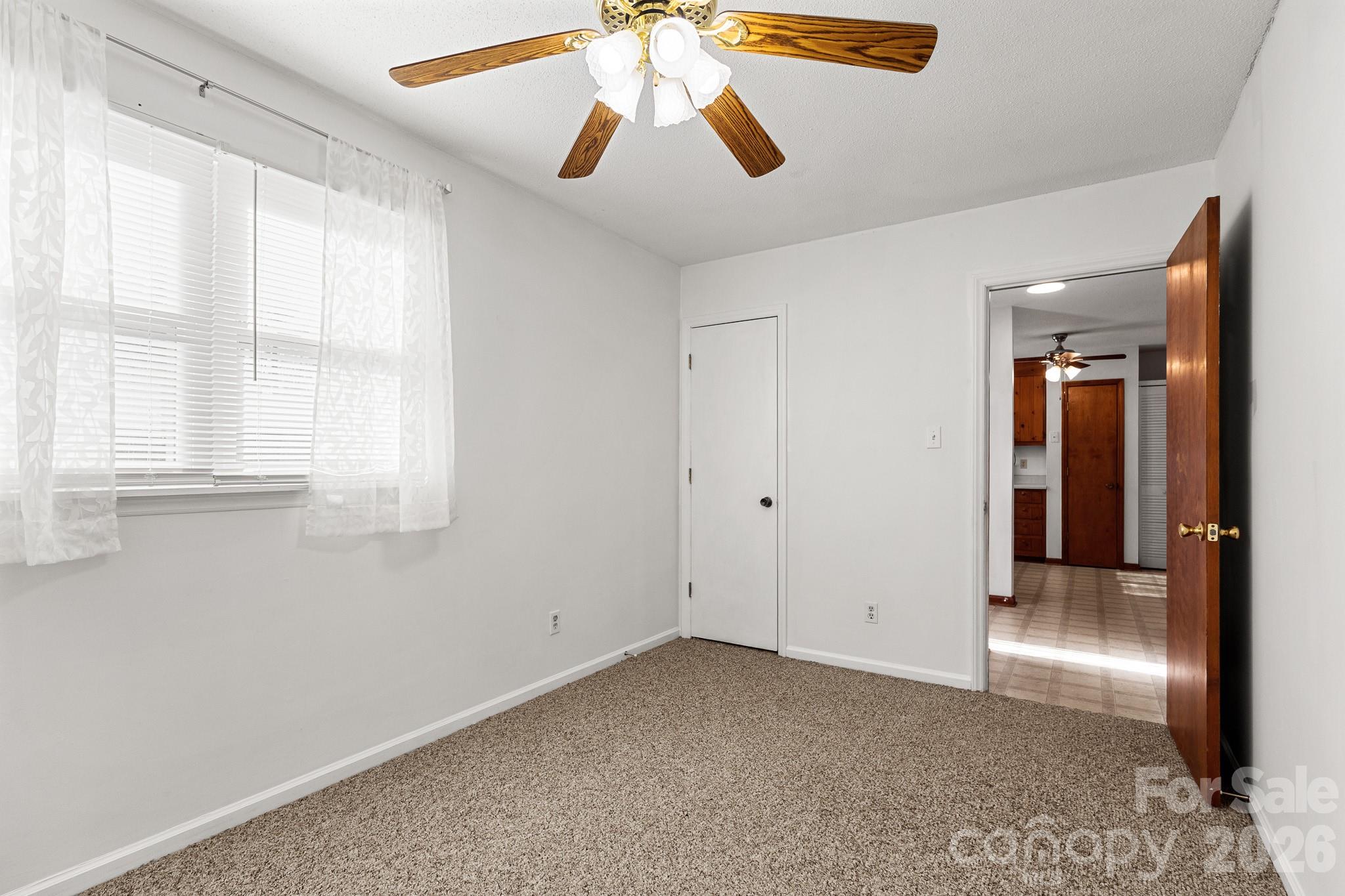 27077 Catamaran Drive Tega Cay, SC 29708 - Photo 21 of 28 a view of an empty room with window and chandelier fan