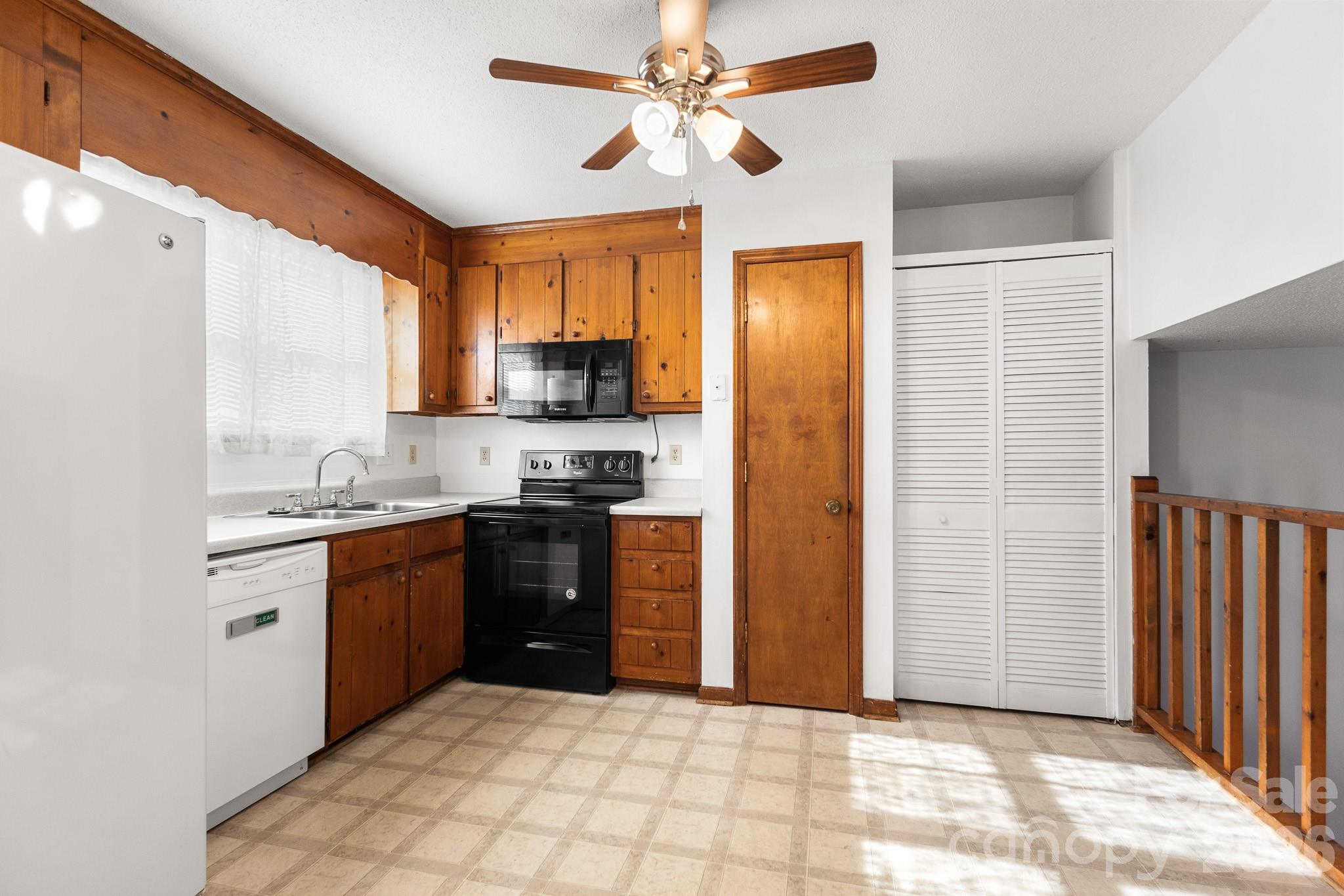 27077 Catamaran Drive Tega Cay, SC 29708 - Photo 7 of 28 a kitchen with stainless steel appliances granite countertop a refrigerator a sink dishwasher a stove with wooden cabinets and floor