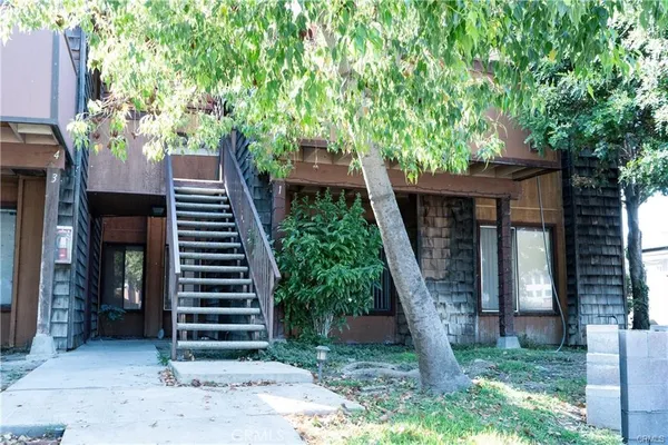 a view of a backyard with large trees and wooden fence
