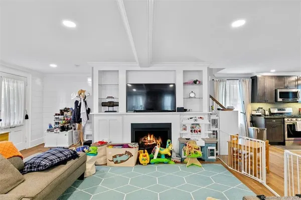 a living room with furniture a flat screen tv and a fireplace