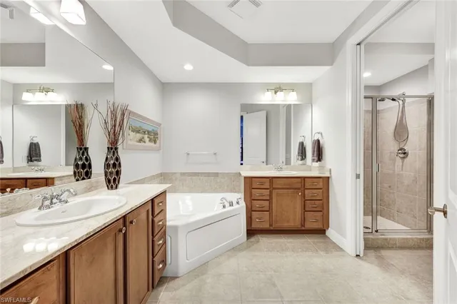 a bathroom with a granite countertop sink a mirror a bathtub and shower
