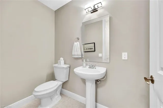 a bathroom with a sink toilet and mirror