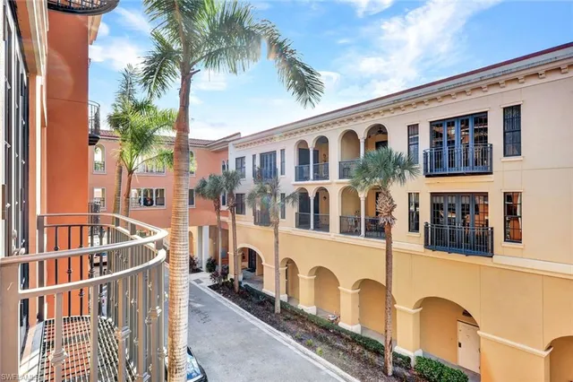 a front view of a building with balcony and trees