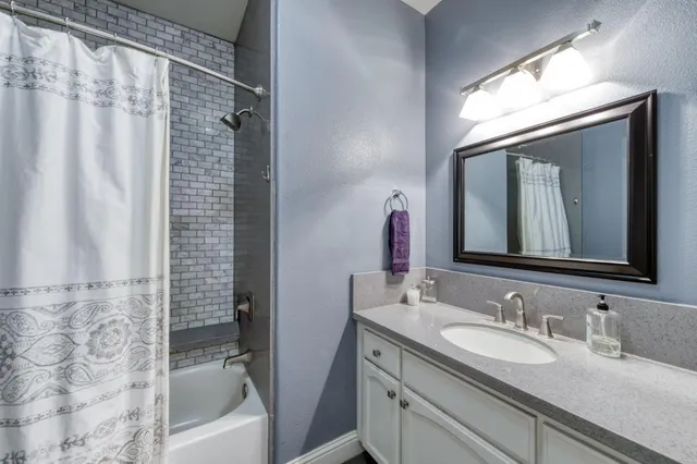 a bathroom with a granite countertop sink mirror bathtub and shower