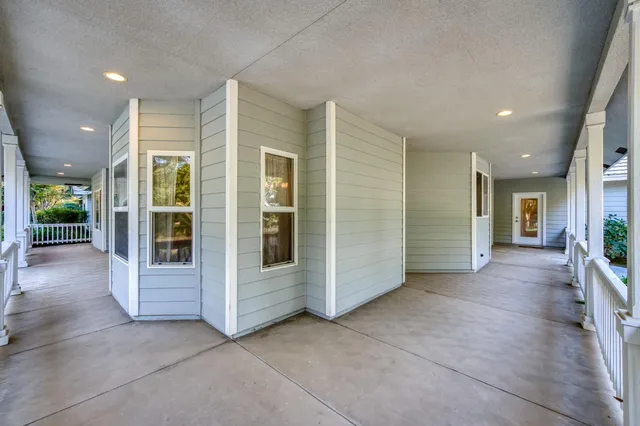 wooden floor in an empty room with a fireplace and a window