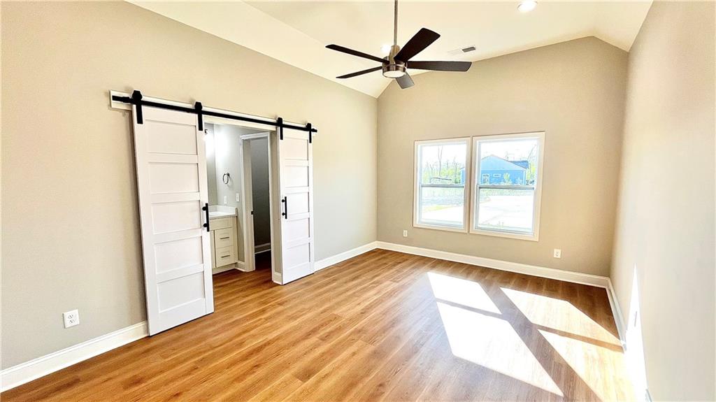 23 S Road Griffin, GA 30224 - Photo 13 of 32 a view of a big room with wooden floor a ceiling fan and windows