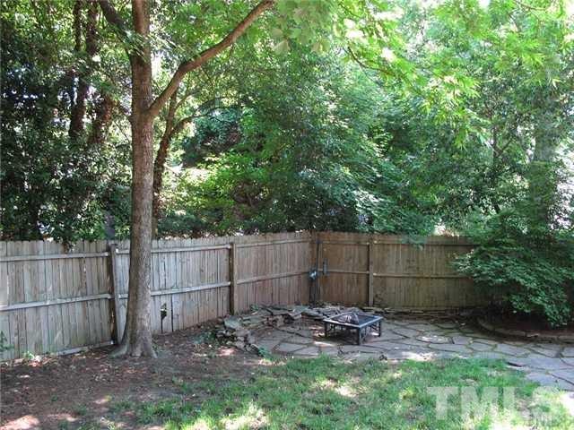 2221 The Circle Raleigh, NC 27608 - Photo 14 of 15 a view of a backyard with a trees and wooden fence