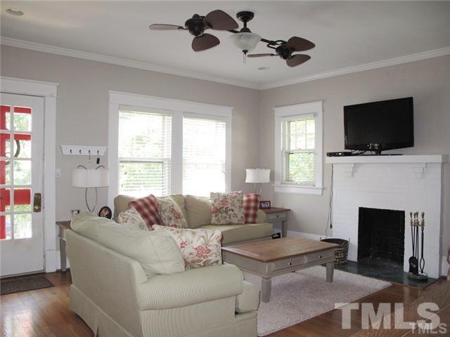 2221 The Circle Raleigh, NC 27608 - Photo 4 of 15 a living room with furniture a fireplace and a flat screen tv