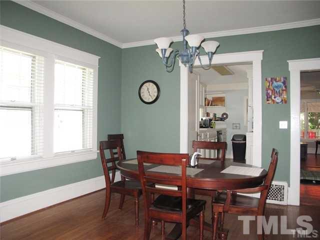 2221 The Circle Raleigh, NC 27608 - Photo 5 of 15 a view of a dining room with furniture a chandelier and wooden floor