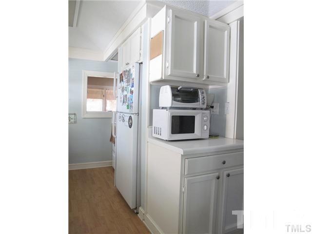 2221 The Circle Raleigh, NC 27608 - Photo 7 of 15 a kitchen with a refrigerator and cabinets