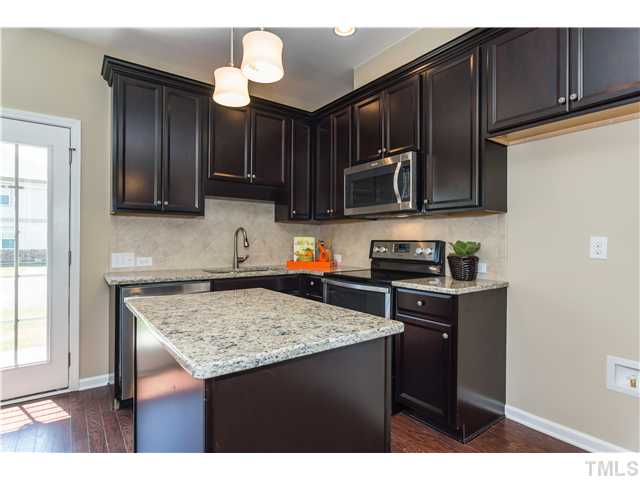 707 Wickham Ridge Road, Unit 160 Apex, NC 27539 - Photo 7 of 21 a kitchen with stainless steel appliances granite countertop a sink stove and refrigerator