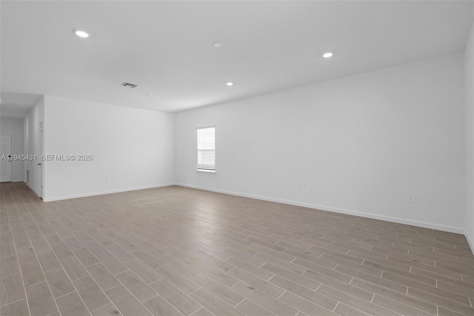 8934 Southwest 69th Terrace Ocala, FL 34476 - Photo 18 of 41 an empty room with wooden floor and windows