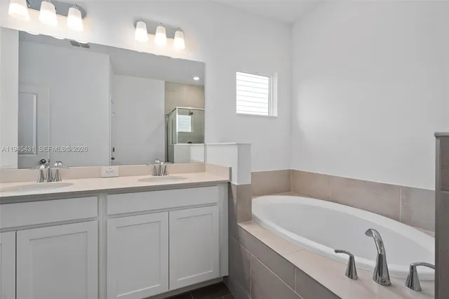 a bathroom with a tub sink and mirror