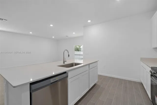 a kitchen with a sink cabinets and wooden floor