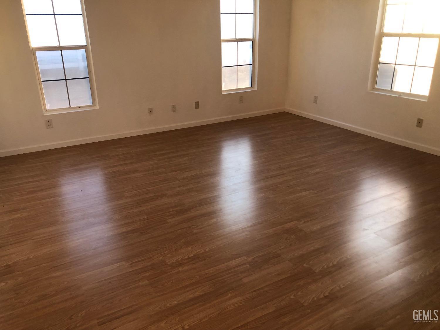 Undisclosed Address Bakersfield, CA 93314 - Photo 12 of 21 an empty room with wooden floor and windows