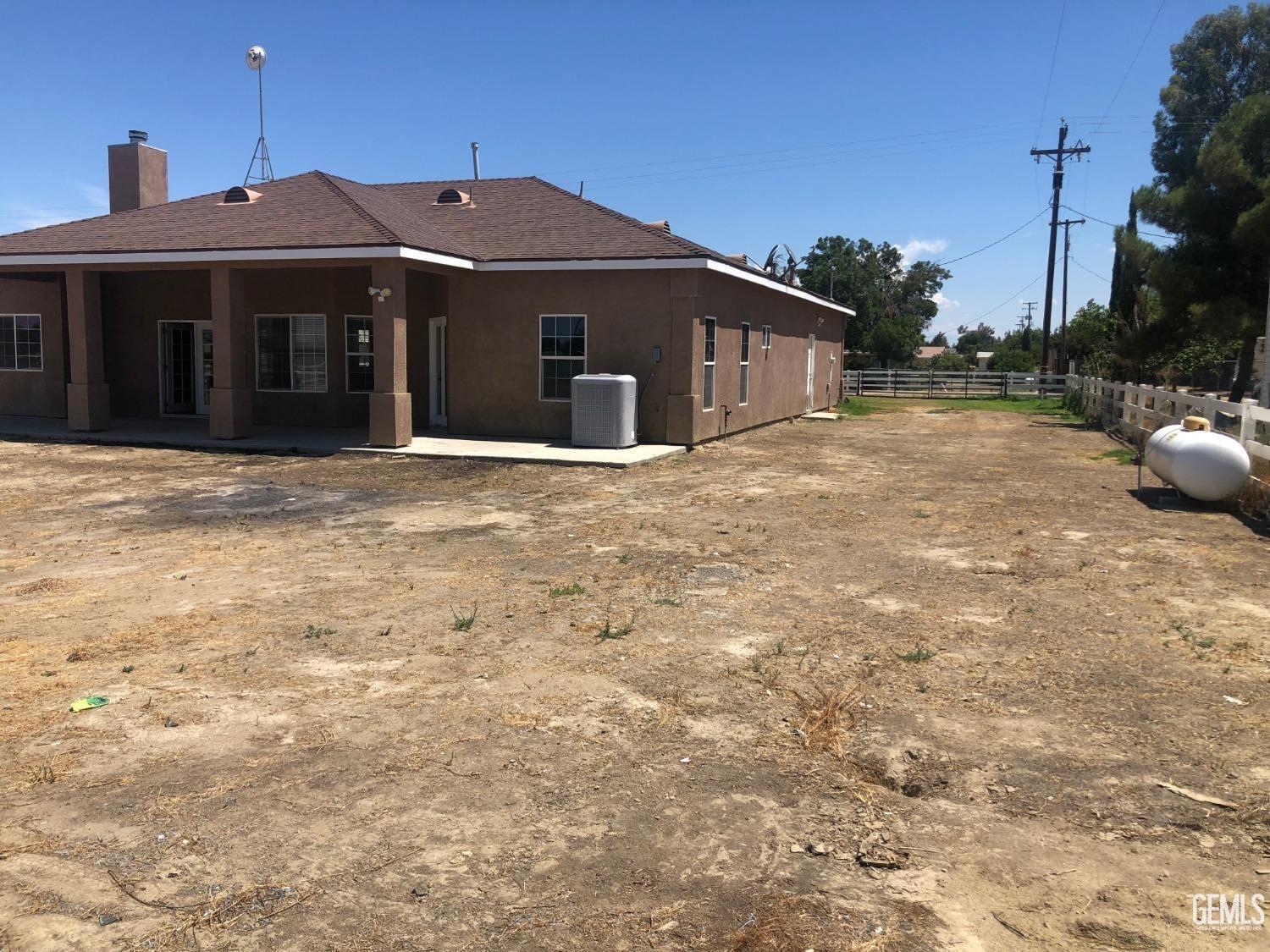 Undisclosed Address Bakersfield, CA 93314 - Photo 5 of 21 a front view of a house with a yard
