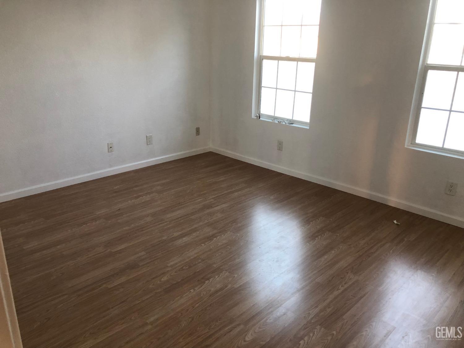 Undisclosed Address Bakersfield, CA 93314 - Photo 8 of 21 an empty room with wooden floor and windows