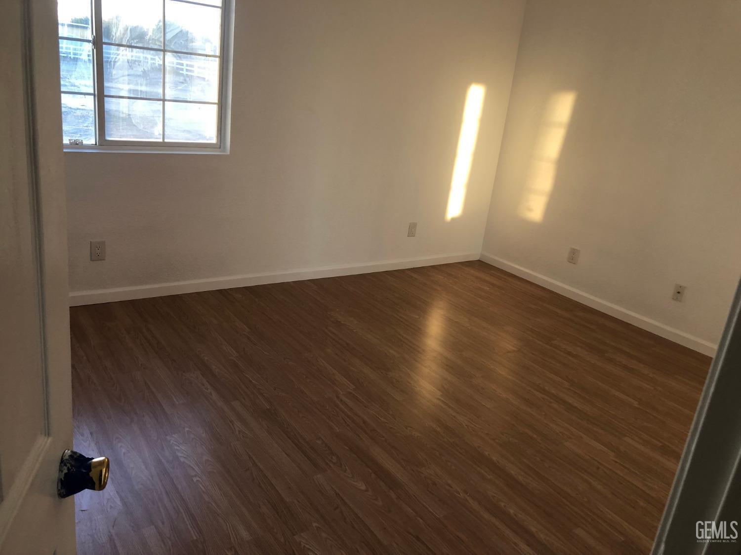 Undisclosed Address Bakersfield, CA 93314 - Photo 10 of 21 an empty room with wooden floor and windows