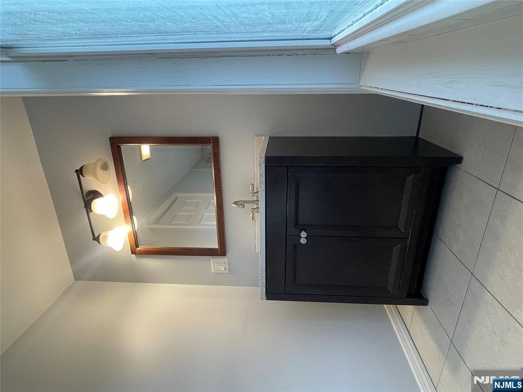 82-84 Maple Avenue, Unit 2 Wallington, NJ 07057 - Photo 12 of 12 a bathroom with a sink and a mirror
