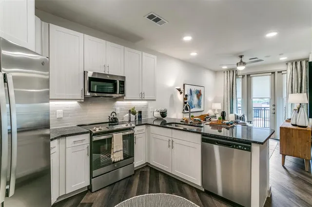 a kitchen with stainless steel appliances granite countertop a sink stove and refrigerator