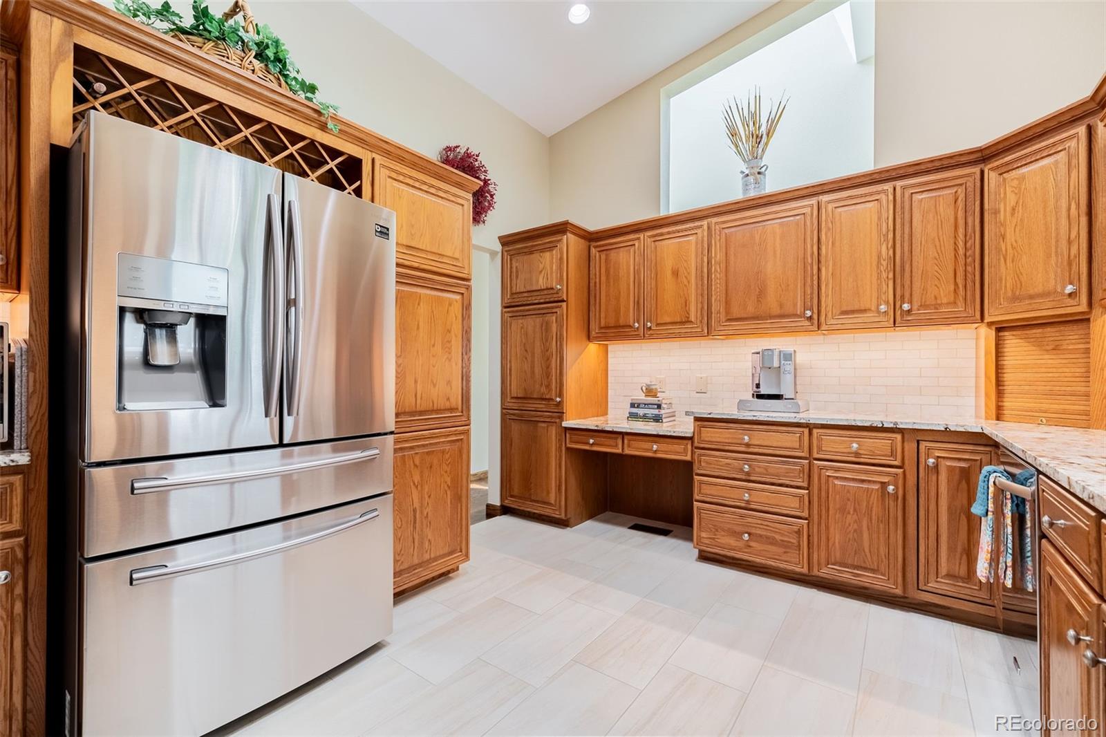 16609 West 77th Drive Arvada, CO 80007 - Photo 11 of 48 a kitchen with stainless steel appliances granite countertop a refrigerator sink and cabinets