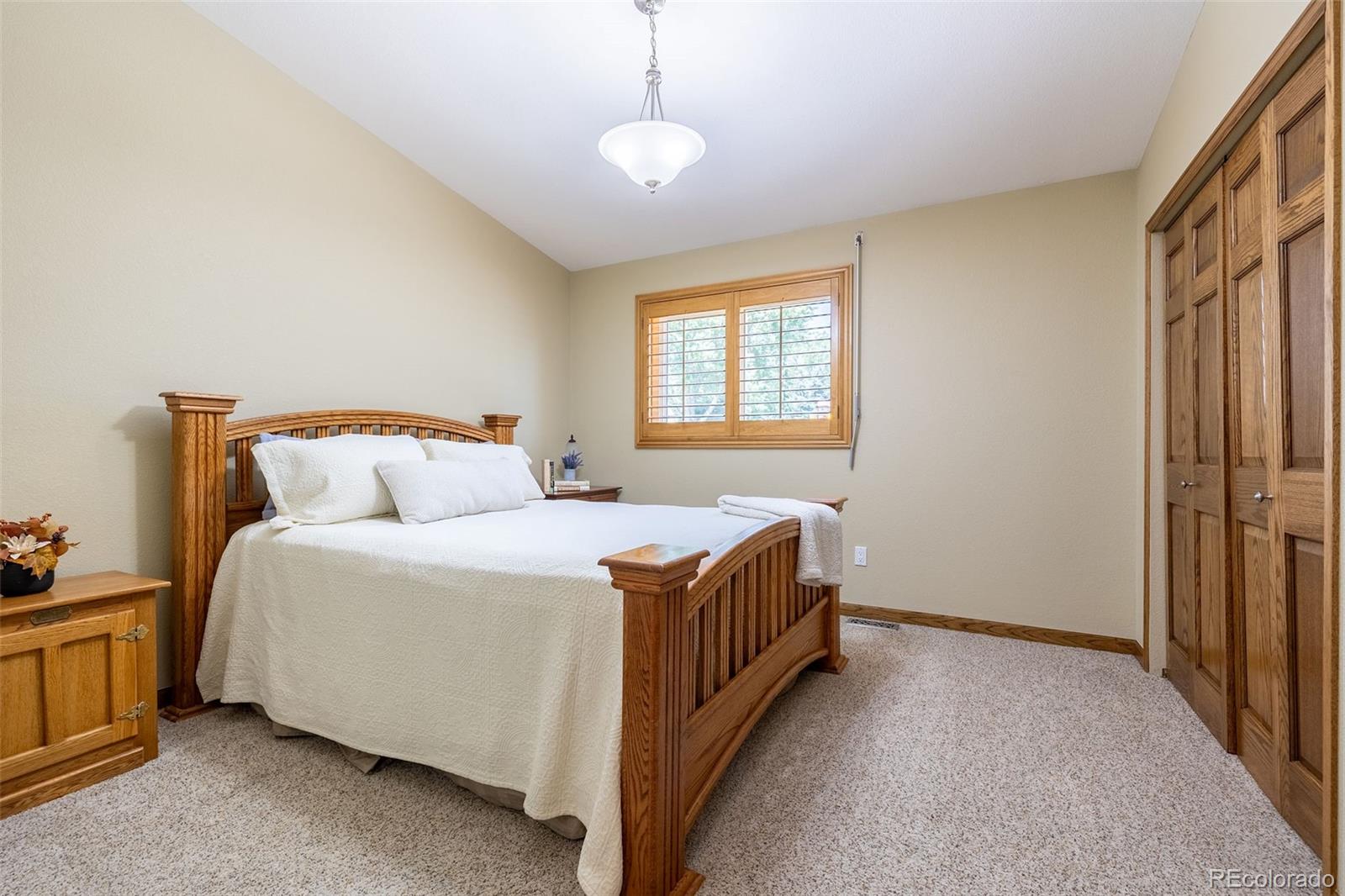 16609 West 77th Drive Arvada, CO 80007 - Photo 19 of 48 a bed room with a bed and a chandelier