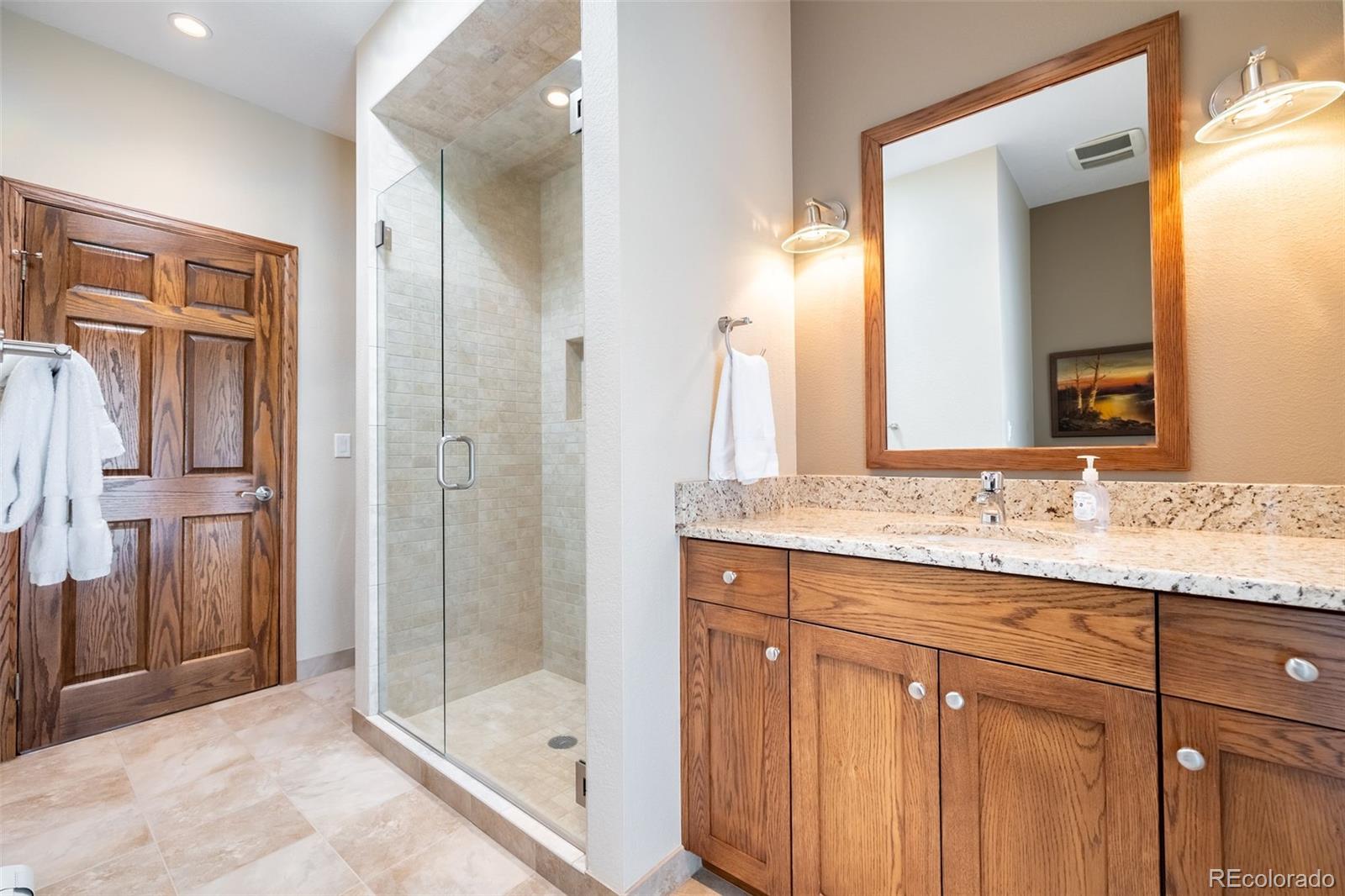 16609 West 77th Drive Arvada, CO 80007 - Photo 21 of 48 a bathroom with a shower sink and mirror