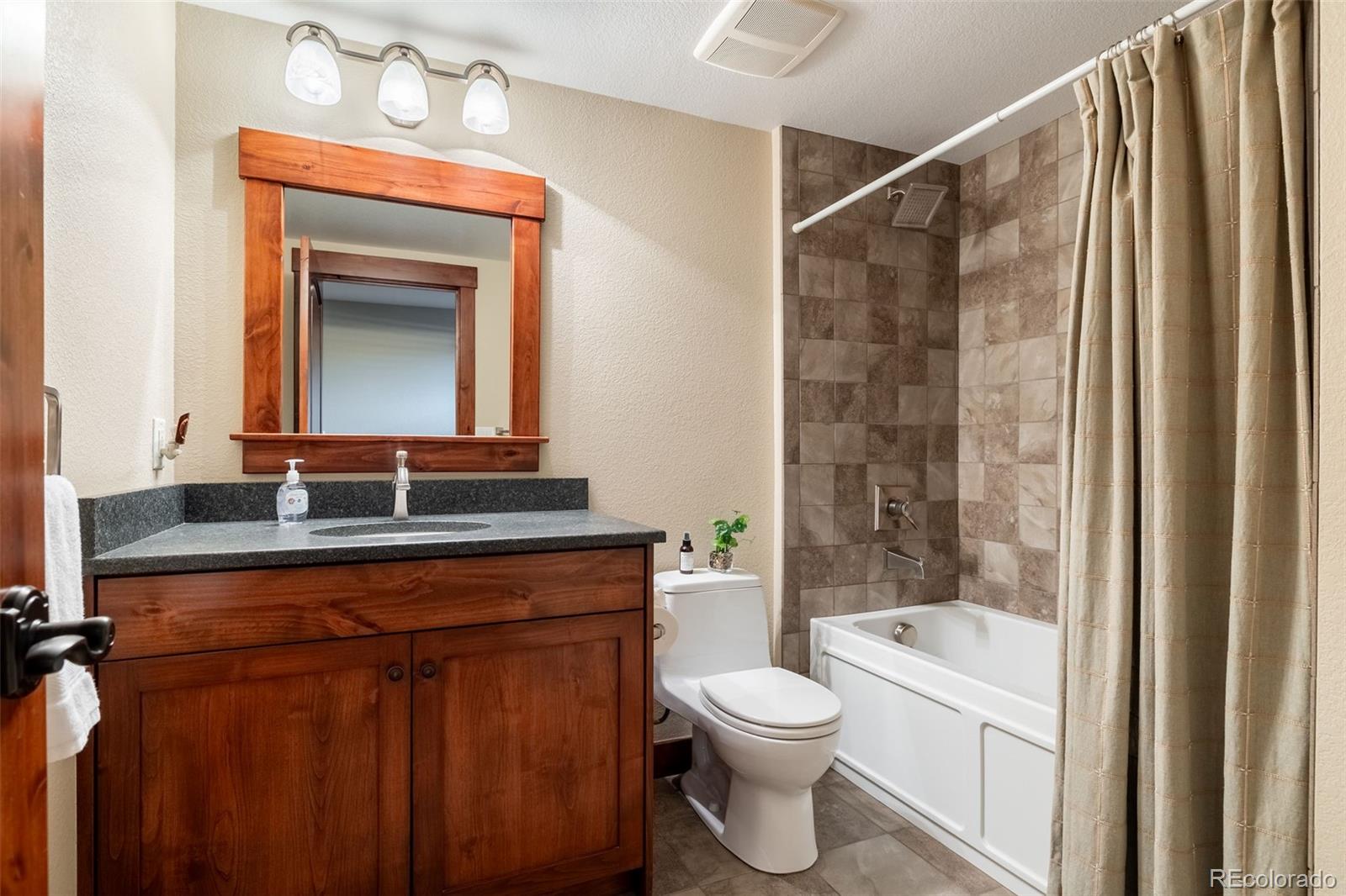 16609 West 77th Drive Arvada, CO 80007 - Photo 33 of 48 a bathroom with a toilet a sink and a bathtub