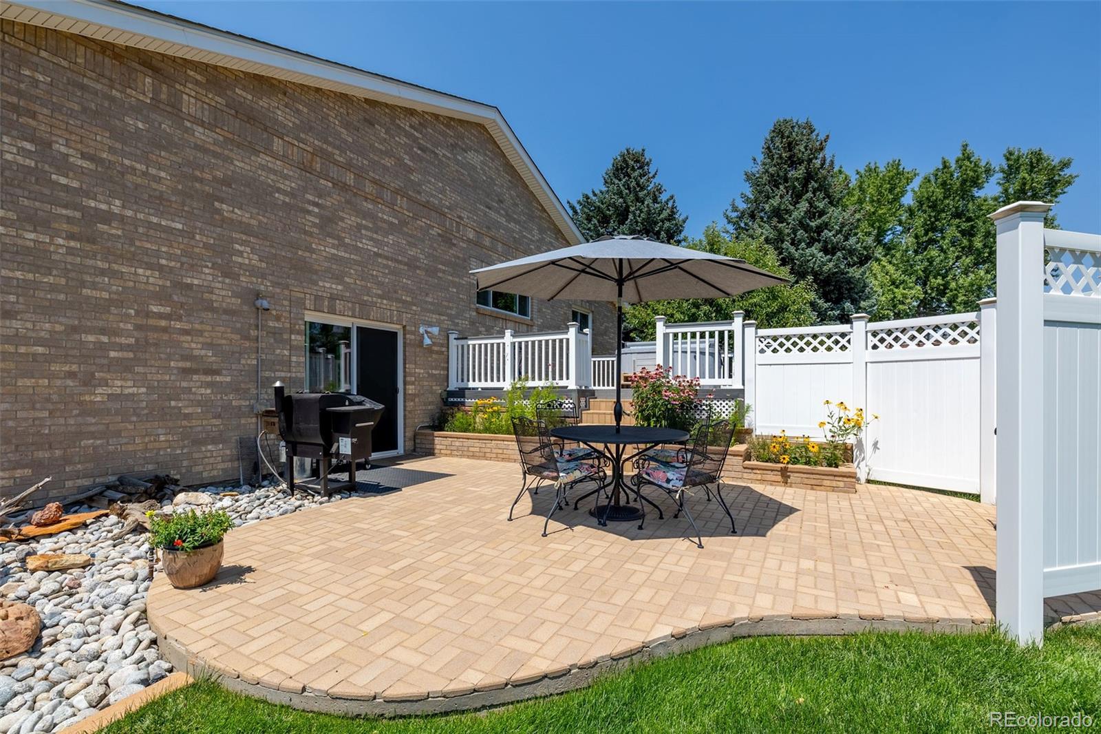 16609 West 77th Drive Arvada, CO 80007 - Photo 43 of 48 a view of a patio with a table and chairs under an umbrella