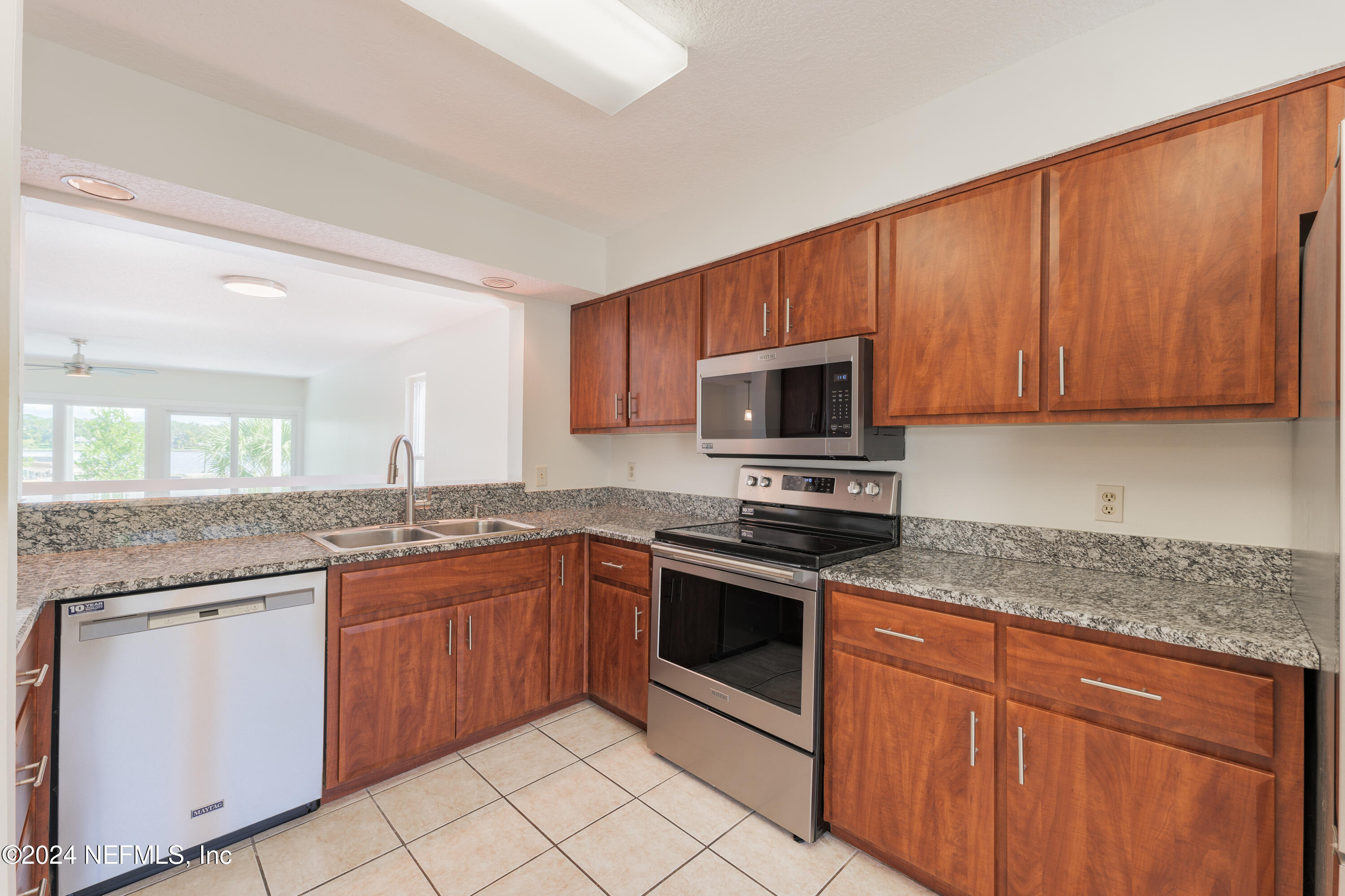 327 Scenic Point Lane Fleming Island, FL 32003 - Photo 11 of 54 a kitchen with stainless steel appliances granite countertop a sink stove and microwave