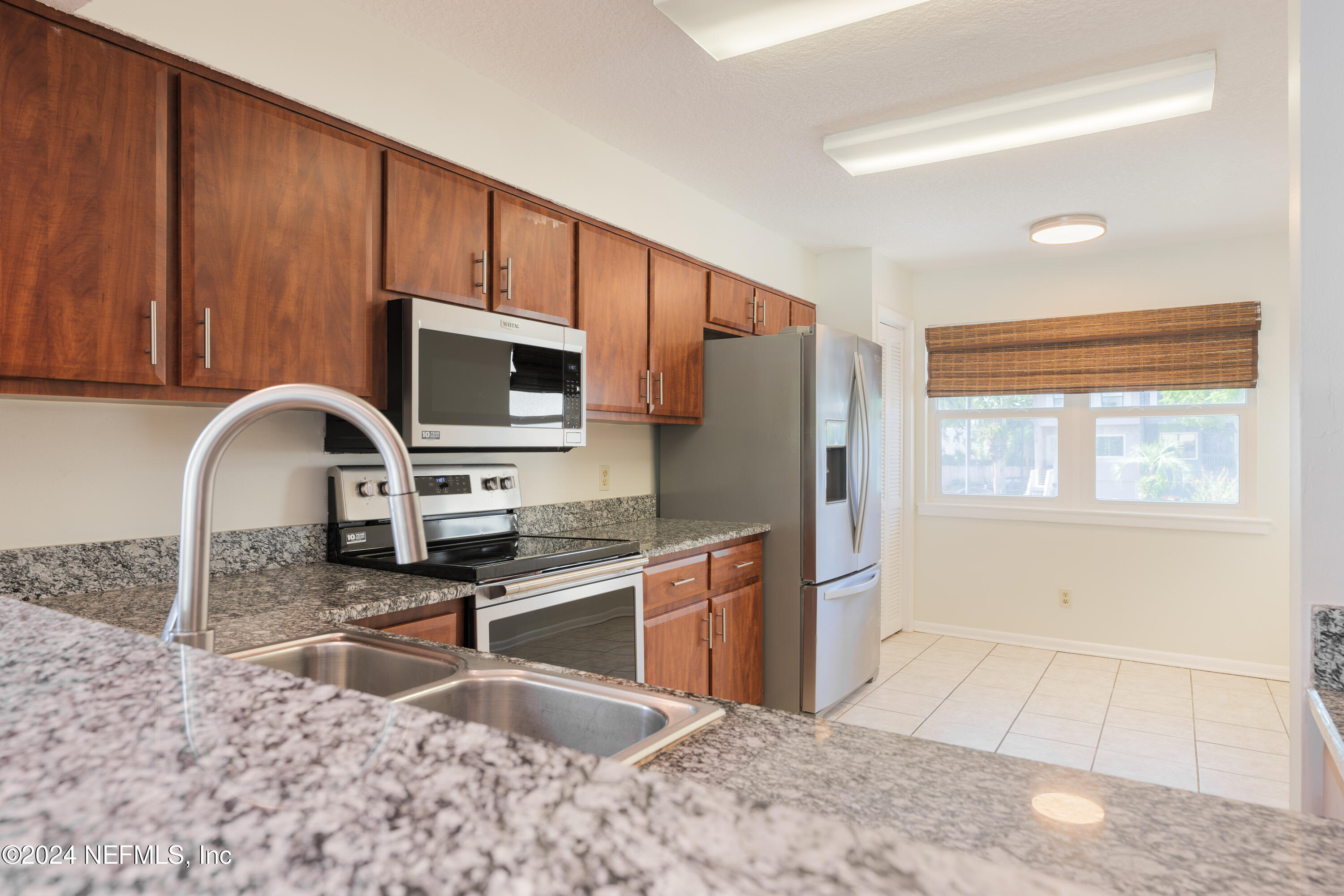 327 Scenic Point Lane Fleming Island, FL 32003 - Photo 12 of 54 a kitchen with stainless steel appliances granite countertop a stove a sink and a microwave