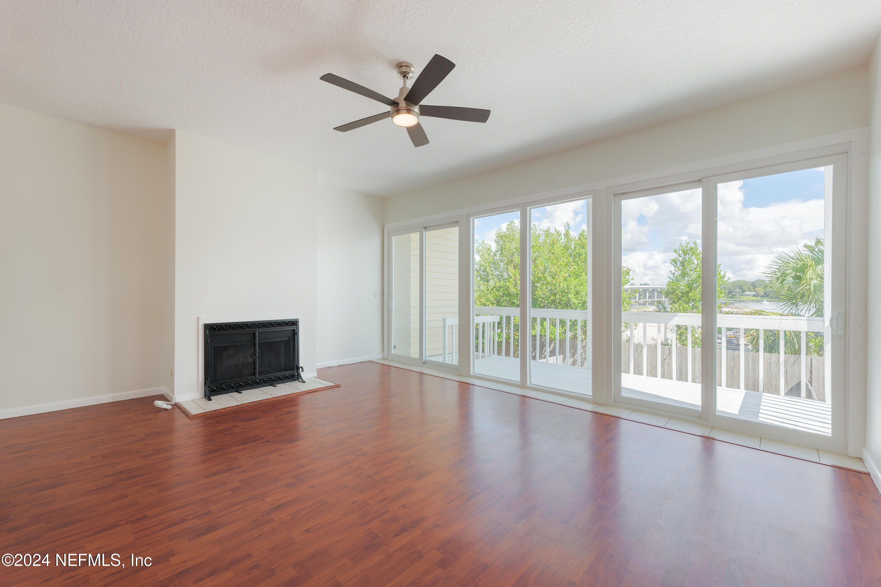 327 Scenic Point Lane Fleming Island, FL 32003 - Photo 17 of 54 a view of a livingroom with wooden floor a ceiling fan and windows