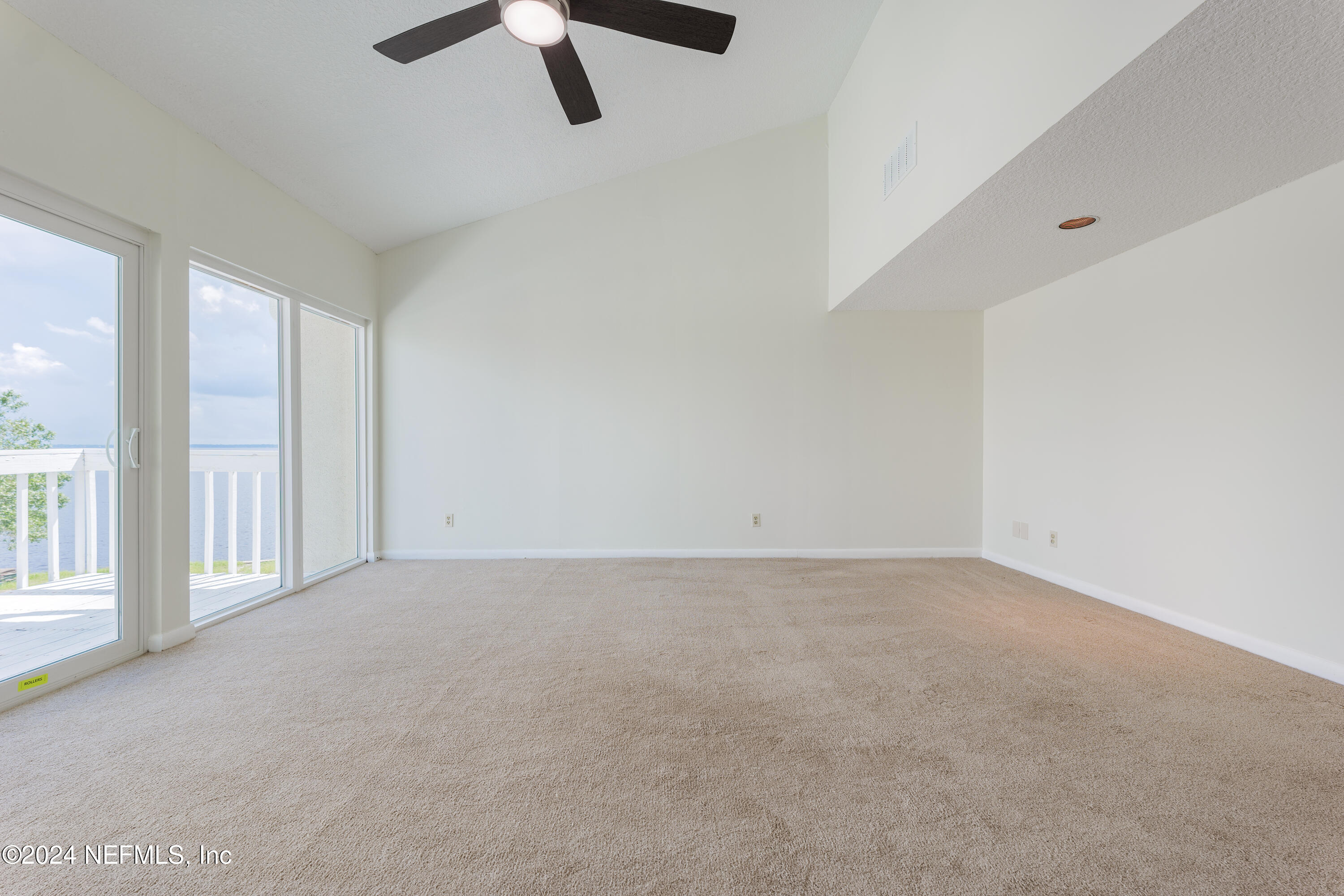 327 Scenic Point Lane Fleming Island, FL 32003 - Photo 26 of 54 an empty room with chandelier fan and windows