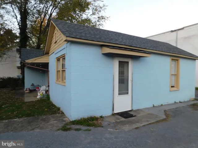 a backyard of a house with wooden wall fire pit and outdoor seating