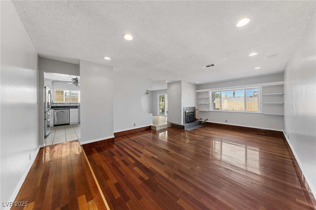 4272 East Russell Road Las Vegas, NV 89120 - Photo 5 of 19 Unfurnished living room with recessed lighting, a textured ceiling, baseboards, and wood finished floors