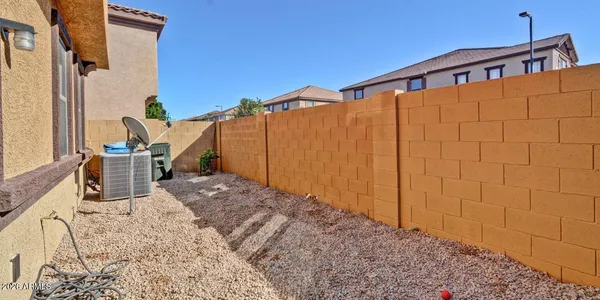 a backyard of a house with barbeque oven table and chairs
