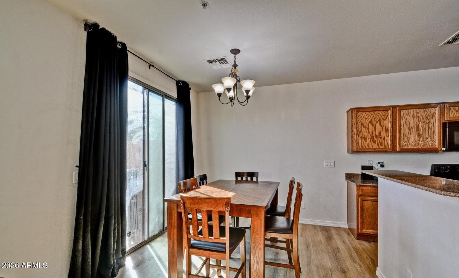 8169 West Groom Creek Road Phoenix, AZ 85043 - Photo 7 of 23 a dining room with furniture a chandelier and wooden floor
