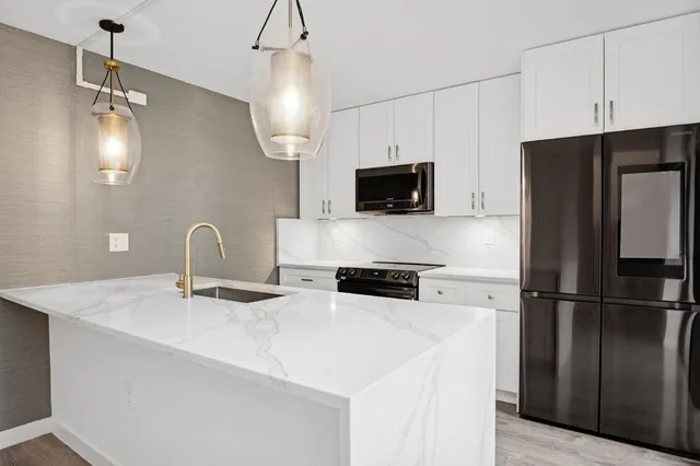 a kitchen with stainless steel appliances a refrigerator sink and microwave