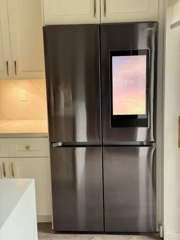 a view of a refrigerator in kitchen with stainless steel appliances wooden floor and a cabinet