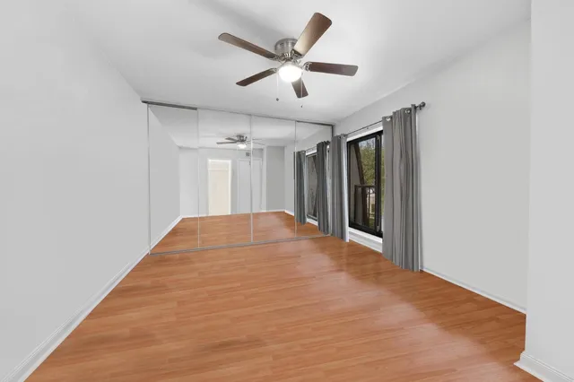 a view of a big room with wooden floor and a ceiling fan