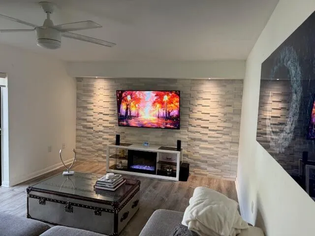 a living room with furniture a flat screen tv and a fireplace